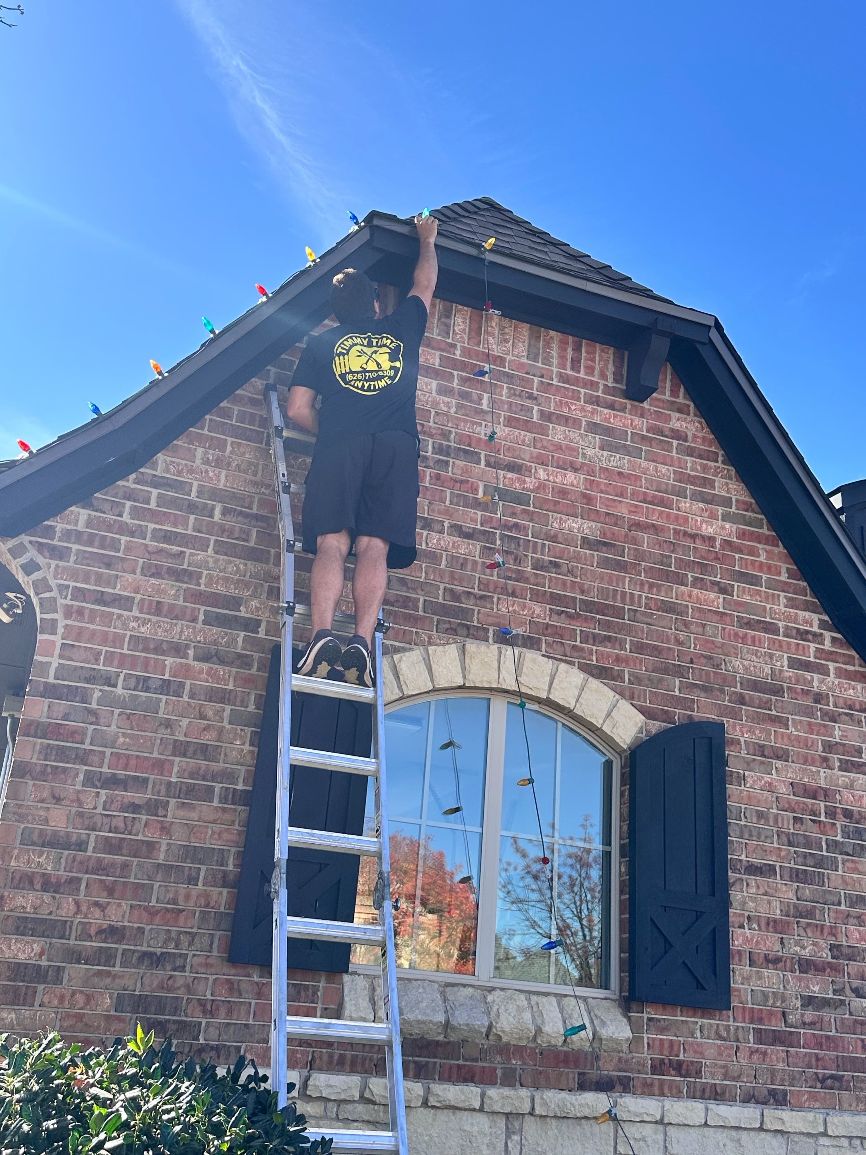 Tim hanging C9 Christmas lights on an Edmond roofline