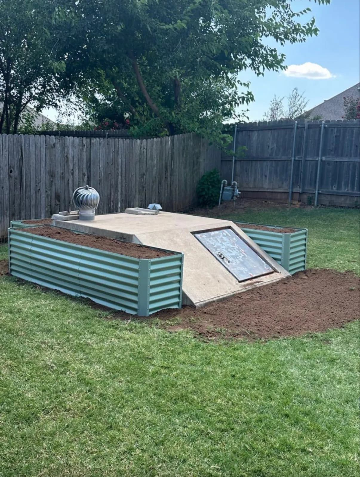 Garden beds beside a storm shelter.